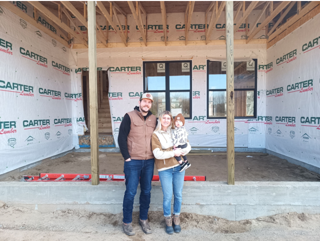 Family in front of home construction site